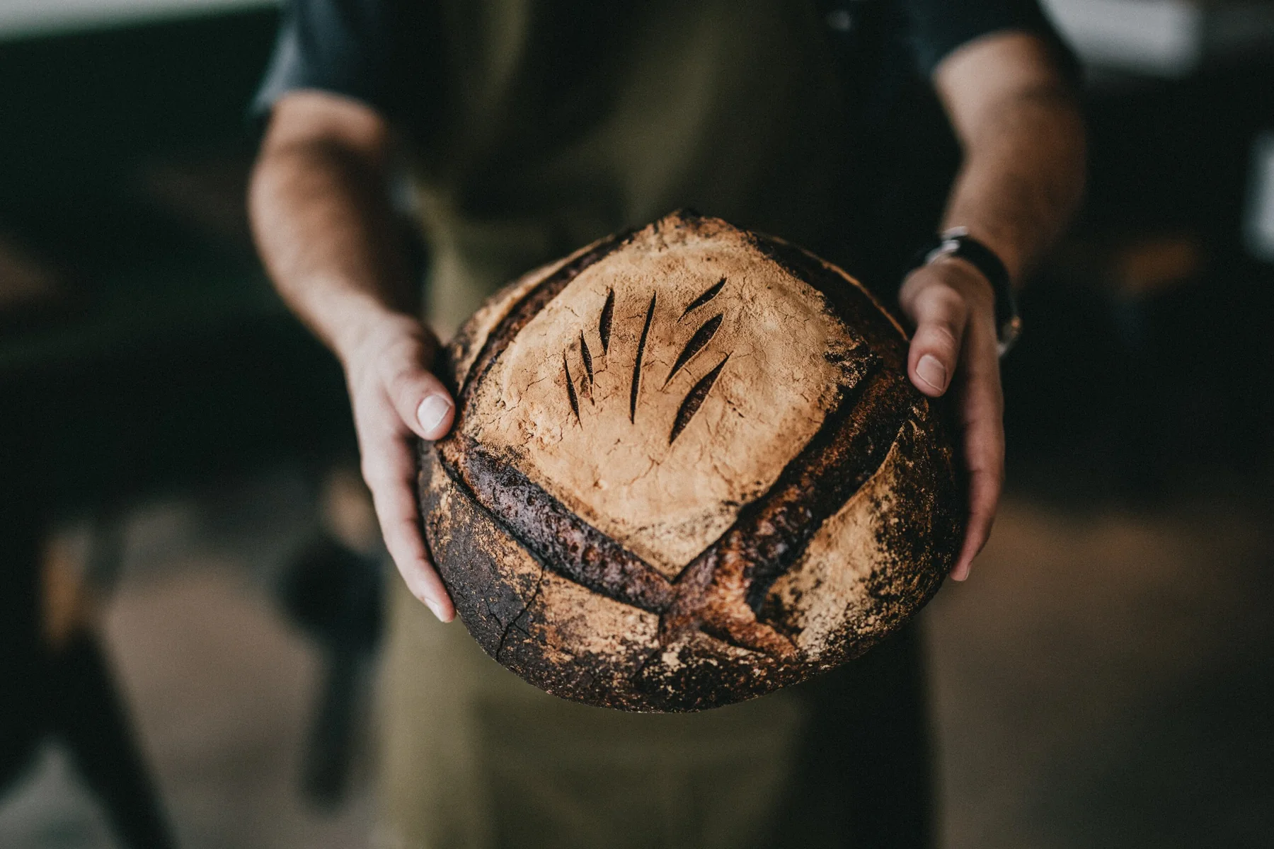 Artisan sourdough loaf held by hand