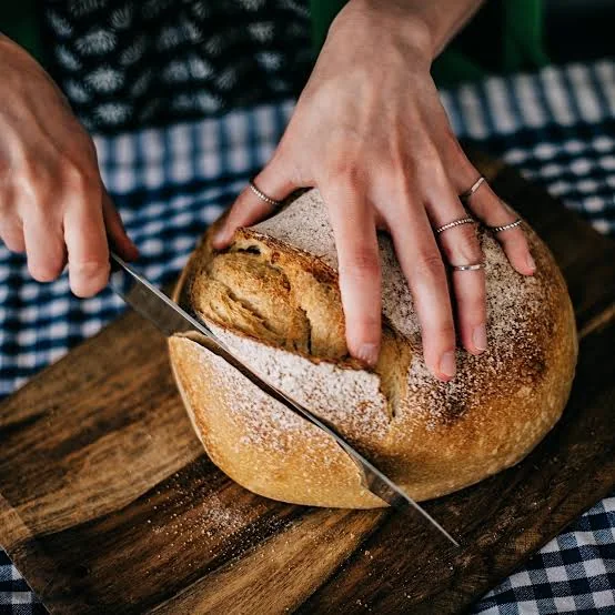 Fresh artisan sourdough bread being sliced